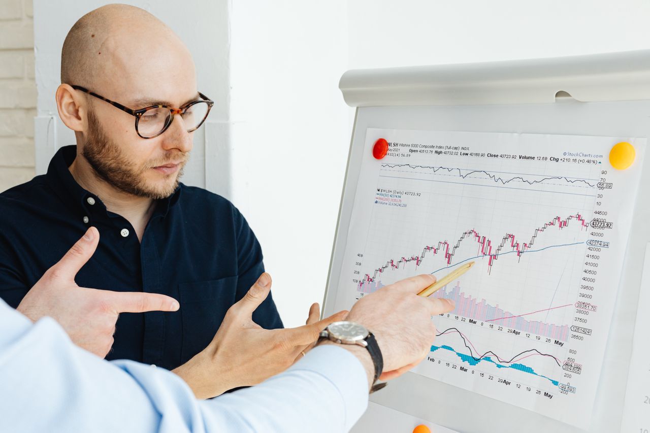 Services Business professionals discussing financial graphs on a flipchart during a daylight meeting.